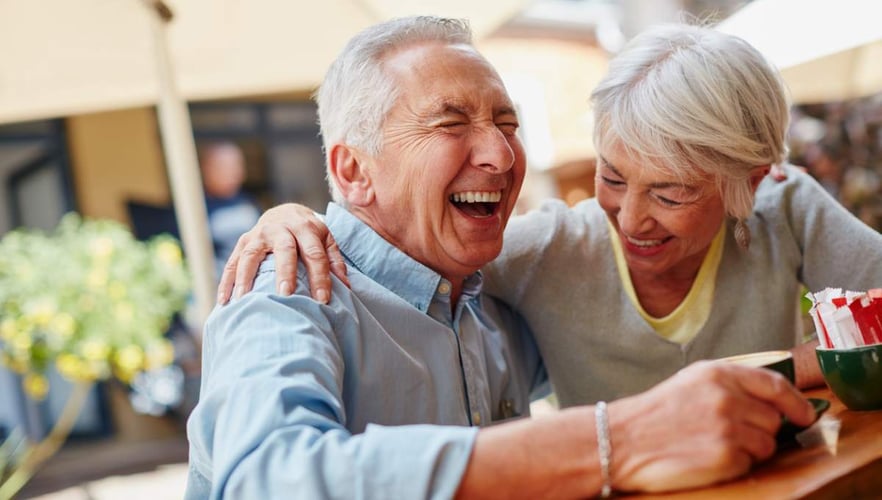 a senior man and senior woman laugh together and embrace Pacific Senior Living blog header